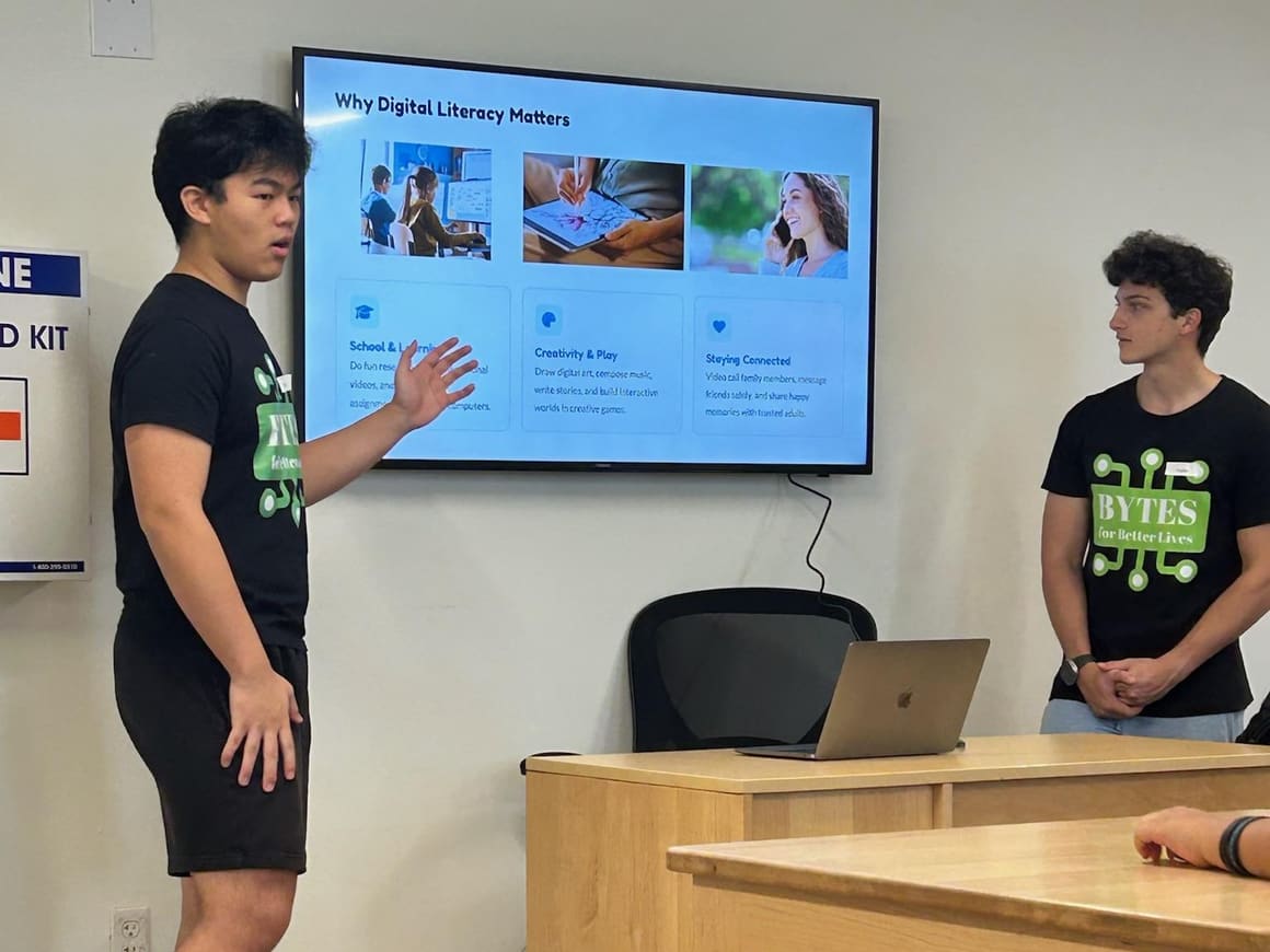A volunteer presents a “Why Digital Literacy Matters” lesson on a classroom screen